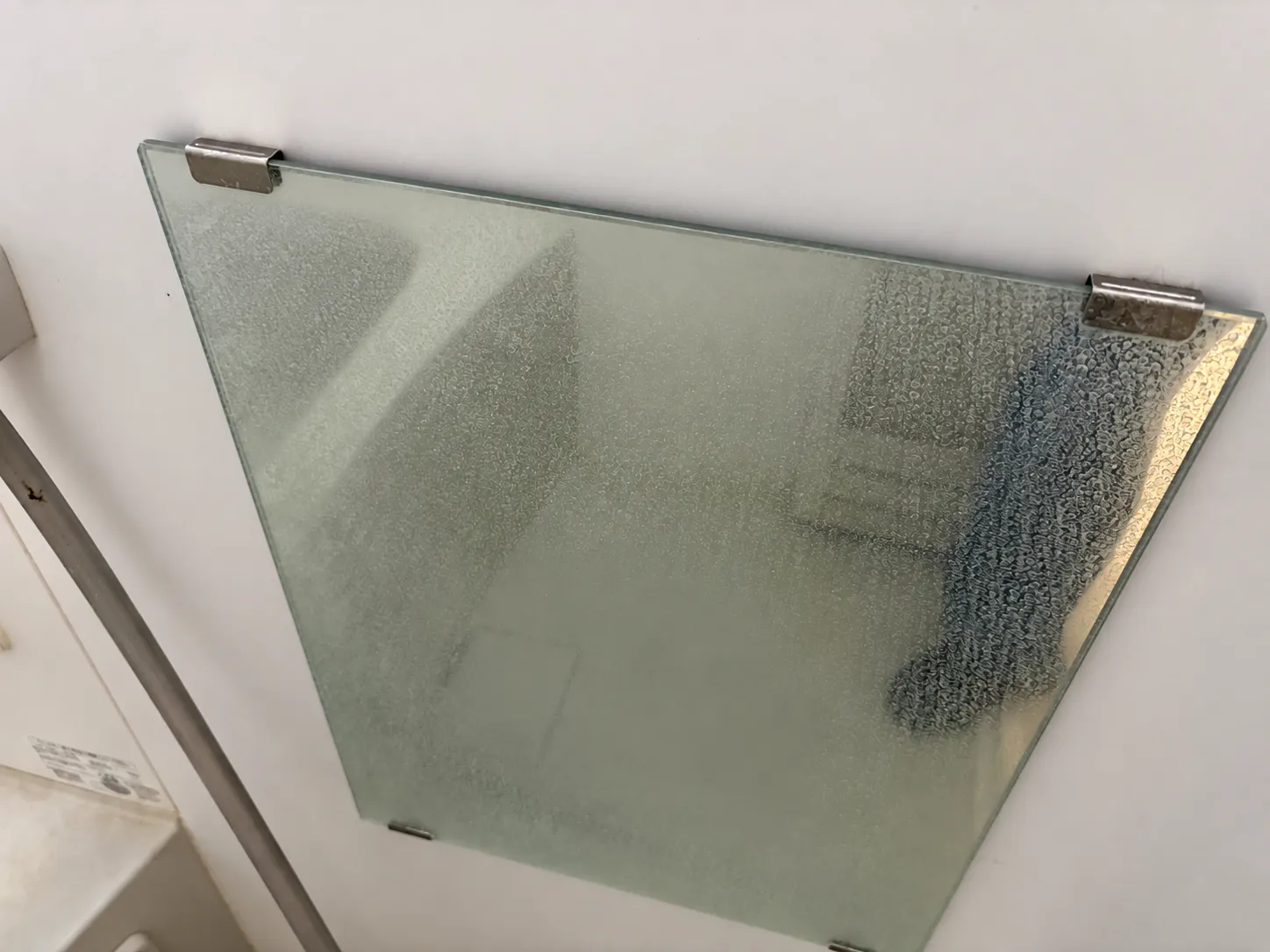 水垢でびっしり曇って景色が映らなくなった浴室の鏡（施工前）